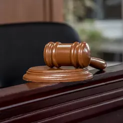 A close up of a judge's gavel on the sound block.